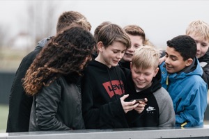 Et billede af en gruppe elever der ser noget på en mobiltelefon